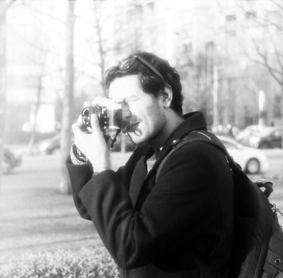 Portrait of a smiling man in a collared shirt with a mid-century warm tone